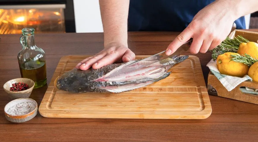 Разрежьте рыбу рыбным ножом горизонтально вдоль спинного плавника