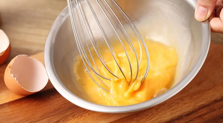 Чтобы омлет получился пышным, нужно отдельно взбить яйца, затем добавить остальные ингредиенты и еще раз немного взбить массу