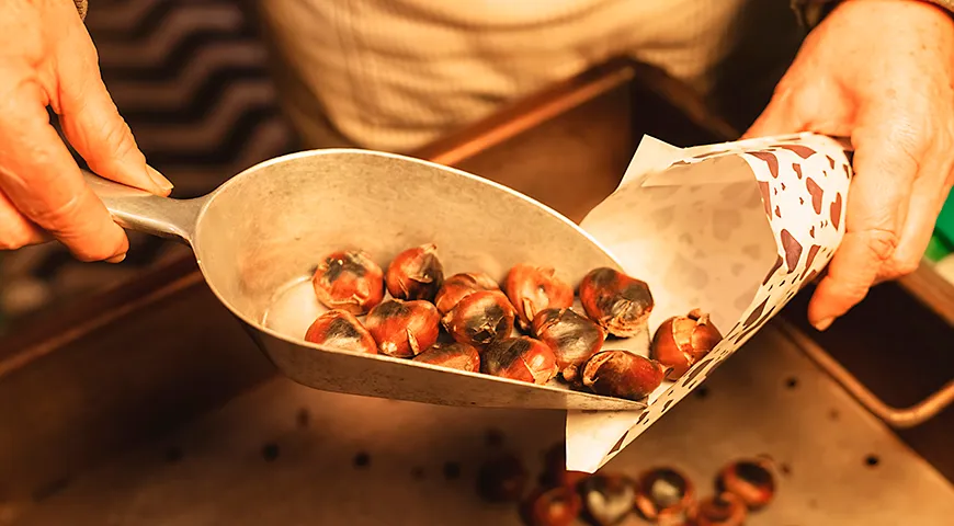 Жареные каштаны в бумажных пакетах — классический зимний европейский перекус, дополняющий глинтвейн