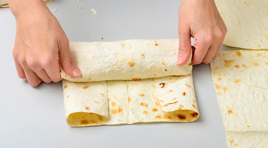 Прием с подгибанием боков не дает начинке выскользнуть по краям в процессе сворачивания и придает роллу классическое прямоугольное сечение