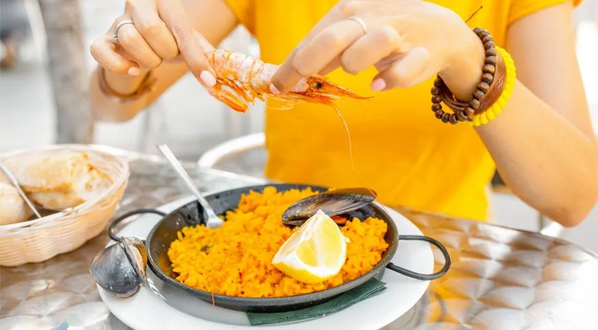 Морепродукты из паэльи едят руками, для риса понадобится вилка или ложка