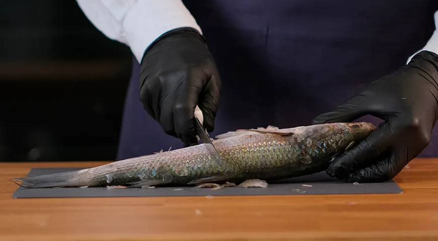 Первый этап подготовки пеленгаса к приготовлению — очистка от чешуи