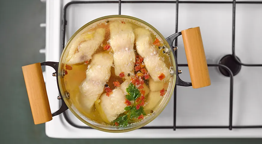 Варите треску до тех пор, пока мякоть не станет белой и будет легко делиться на крупные «хлопья»