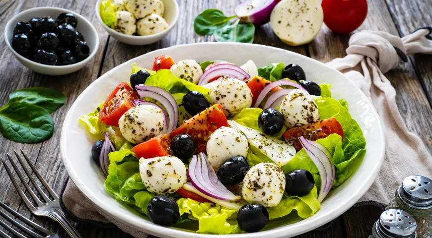Иногда в греческий салат вместо феты добавляют мини-моцареллу. Такой вариант очень нравится детям