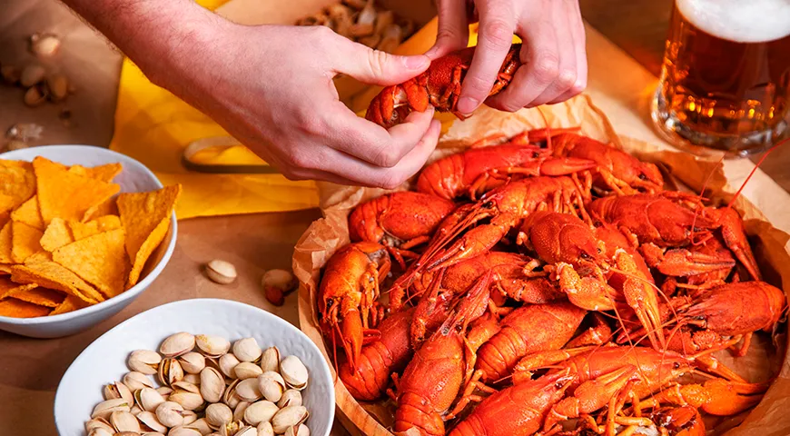 Отделите брюшко (шейку) рака от головогруди, аккуратно потянув их в разные стороны, и не забудьте выпить ароматный сок, скопившийся на месте разлома