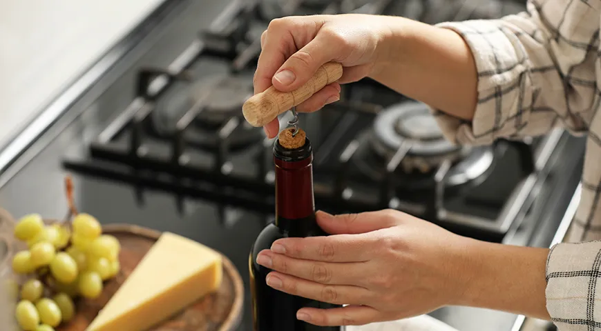 Используя штопор, установите его строго по центру пробки и, придерживая бутылку, плавно вкручивайте по часовой стрелке