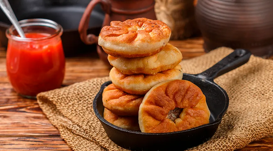 Самый популярный вариант — классический жареный беляш из дрожжевого теста, сформированный в виде круглой лепешки с дырочкой в центре