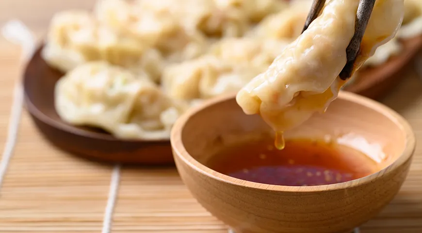 Паровые вонтоны с начинкой из рубленой свинины и курицы, подаваемые с кунжутным маслом