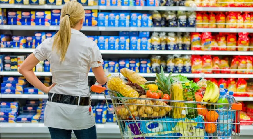 Девушка в супермаркете выбирает продукты