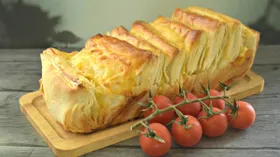 Хлеб-гармошка из слоёного теста с помидорами и сыром