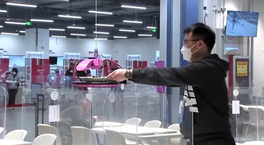 Робот-повар обслуживает участника зимней Олимпиады в Пекине