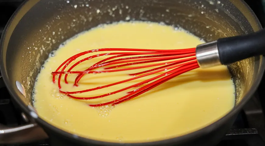 Чтобы заварной крем не пригорел, постоянно помешивайте его венчиком