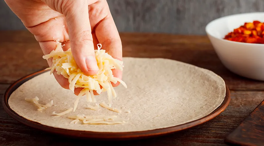 Основное различие тортильи с сыром зависит от типа теста (плотная кукурузная или мягкая пшеничная лепешка) и сыра 