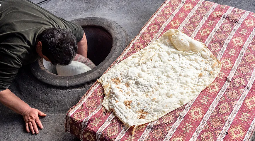 Армянский лаваш готовят, прилепляя тонкое тесто к стенкам печи-тонира